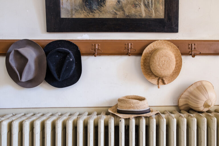 Wall,Hanger,With,Various,Hats,On,It,,Radiator,And,Old